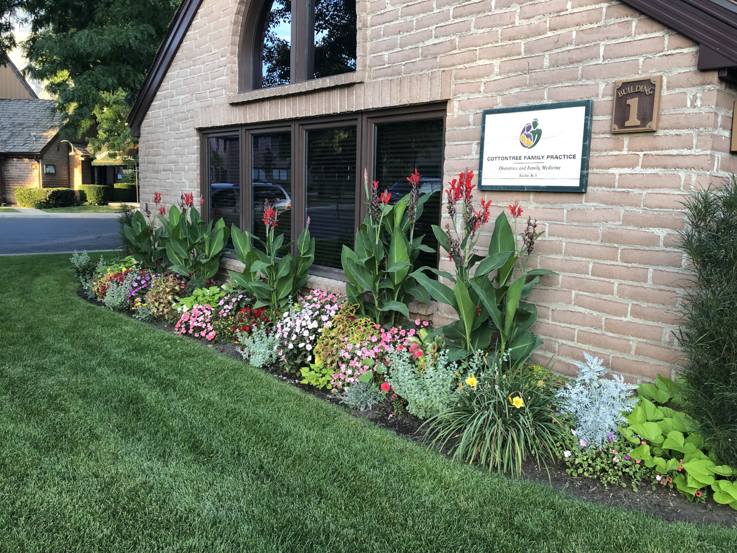Colorful flower beds in front of brick building